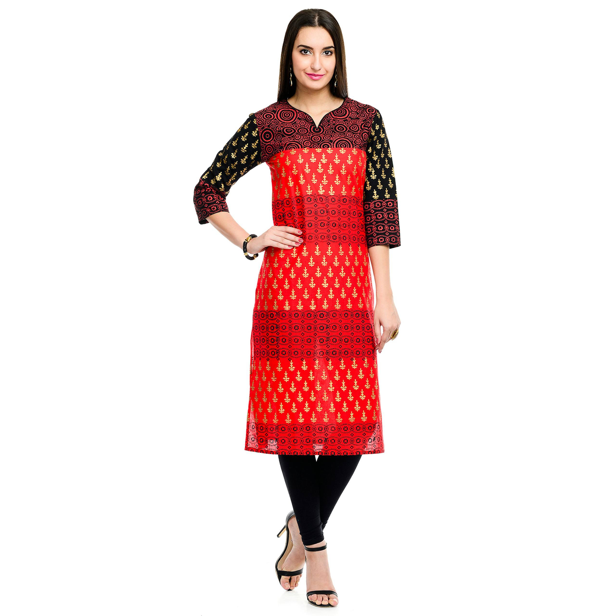 A stylish model wearing a traditional red and black patterned dress with elegance.